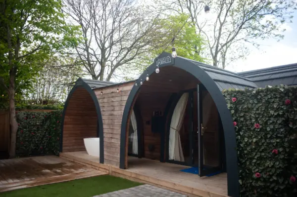 Bespoke deluxe glamping pod with side entry, outdoor decking, and garden views